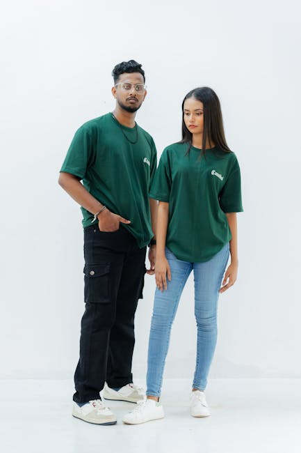 Male and female models in matching green t-shirts and casual outfits on a white backdrop.